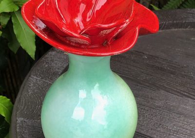 vase-en-ceramique-vert-avec-un-col-en-forme-de-coquelicot-rouge