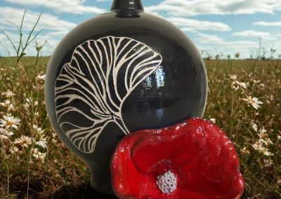 vase-sperique-noir-avec-en-decoration-une-feuille-de-gingko-et-un-coquelicot-en-ceramique