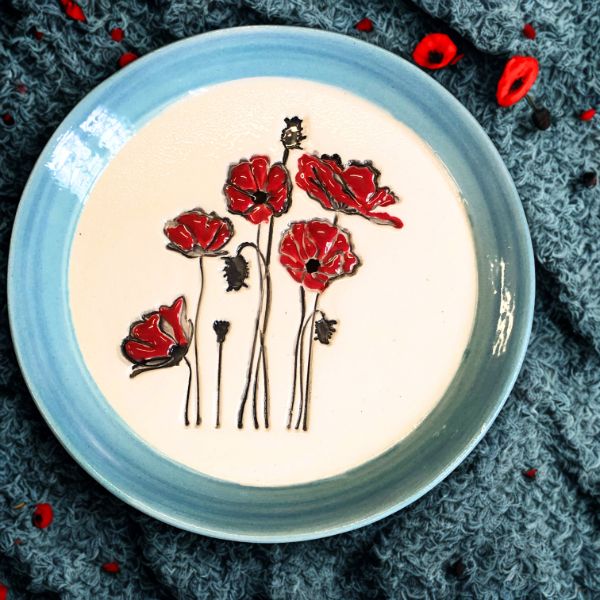 petite-assiette-en-ceramique-artisanale-a-la-bordure-bleue-degradee-avec-des-coquelicots-au-centre